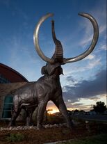 Photo of life-size bronze mammoth sculpture at sunset
