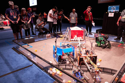 Photo of teams competing at a robotics competition.