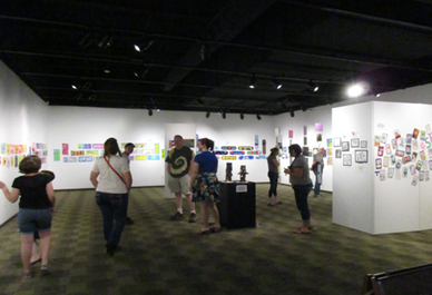 Temporary gallery with visitors viewing the All School Art Show