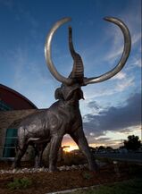 Photo of life-size bronze mammoth sculpture at sunset