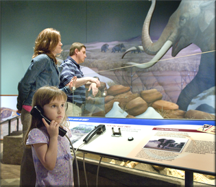Photo of people viewing and listening to the exhibit displays at the Washakie Museum.